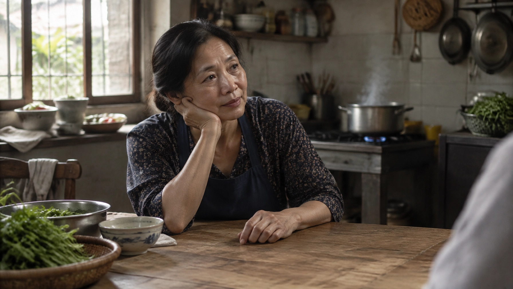 A woman pausing in a market kitchen in morning light, steam rising from a pot nearby.